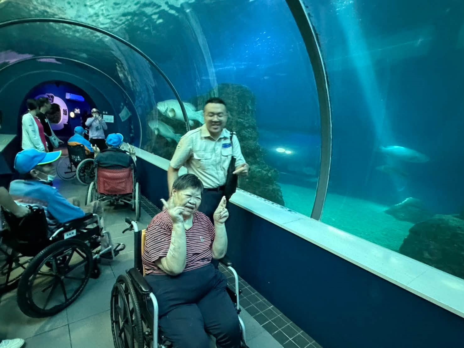 長輩走過海底隧道欣賞悠游的魚群